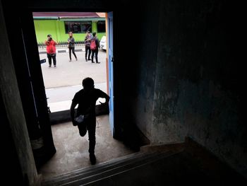 Rear view of people walking in corridor of building