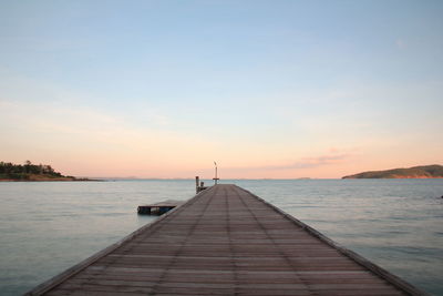 Pier over sea against sky during sunset