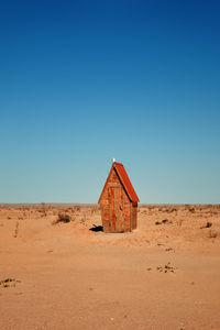 Small wooden house with red roof in kyzylkum desert, uzbekistan