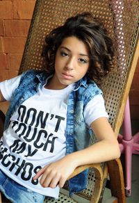 Portrait of girl sitting on chair at home