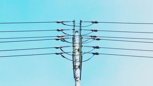 Low angle view of electricity pylon against clear sky