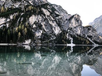 Reflection of rocks in lake against sky