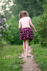 Rear view of woman walking on field