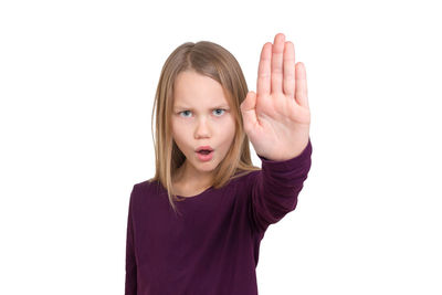 Portrait of girl gesturing stop sign against white background