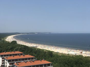 High angle view of sea and buildings against clear sky