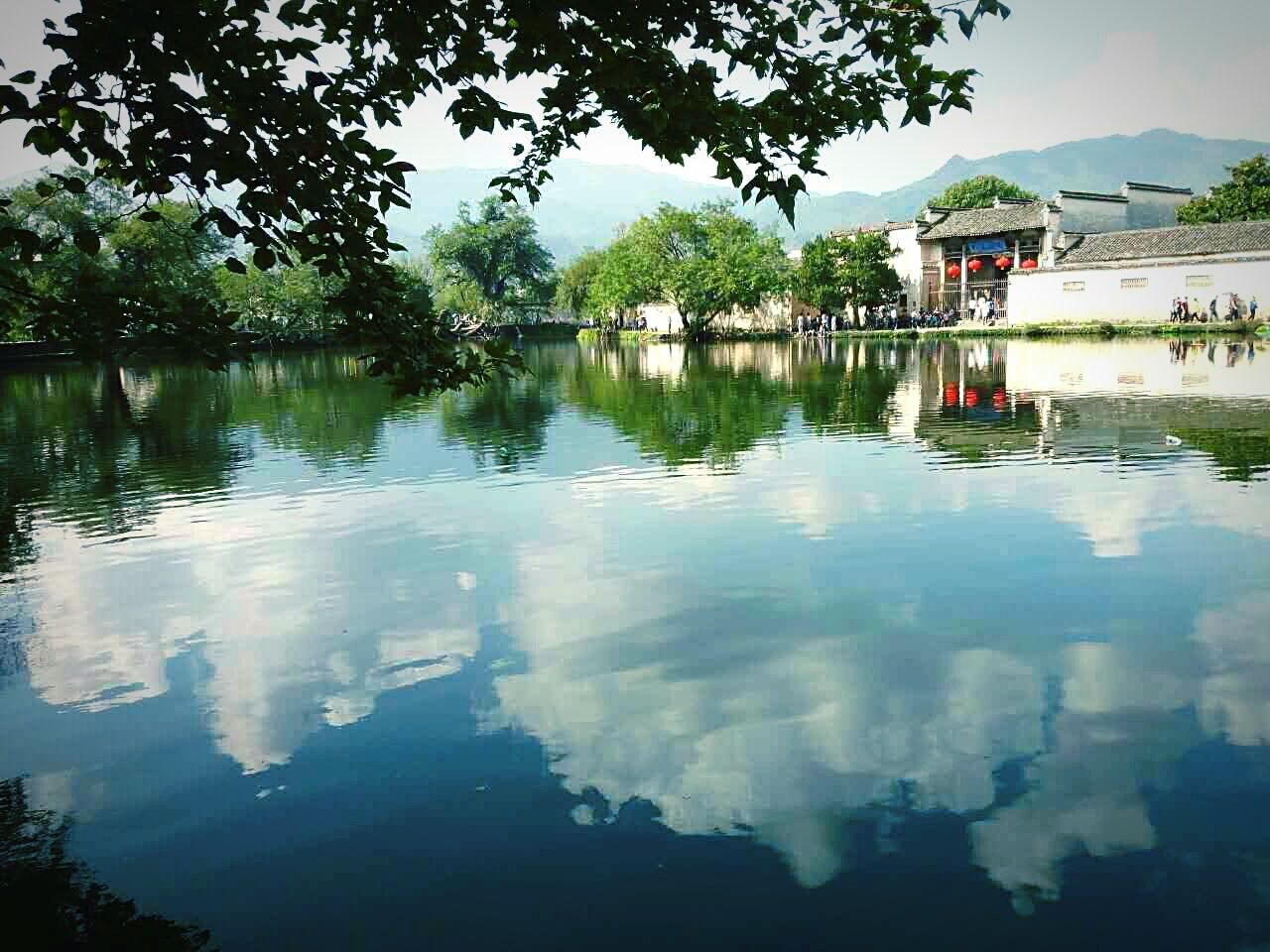 SCENIC VIEW OF CALM LAKE BY TREES AND MOUNTAIN AGAINST SKY