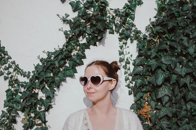 Portrait of young woman wearing sunglasses against sky