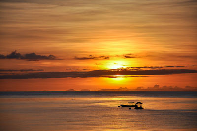 Scenic view of sea against orange sky