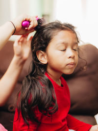 Mother combing daughters hair