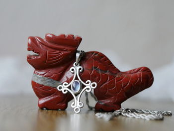 Close-up of figurine and necklace on table