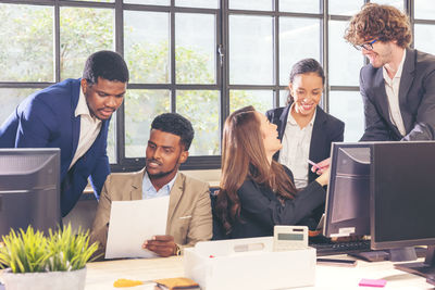 Colleagues in a boardroom discussion, seated at a table together, 