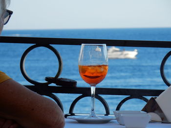 Close-up of beer glass against sea