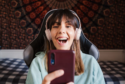 Smiling young woman video conferencing over mobile phone