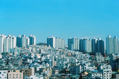 Modern buildings in city against clear blue sky