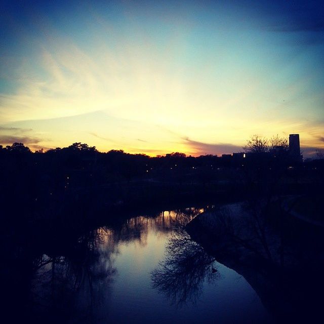 sunset, water, reflection, silhouette, tree, sky, lake, tranquility, tranquil scene, scenics, beauty in nature, waterfront, river, nature, idyllic, building exterior, built structure, dusk, orange color, standing water