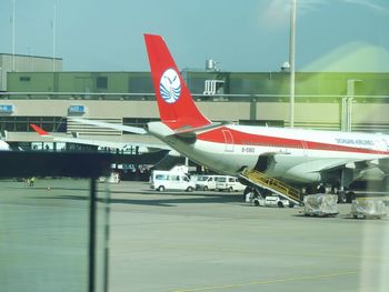 Airplane on airport runway against sky