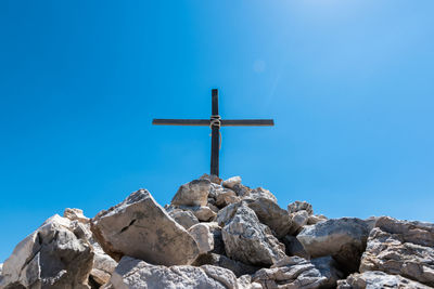 Low angle view of cross against clear blue sky