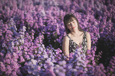 Woman standing amidst purple flowering plants