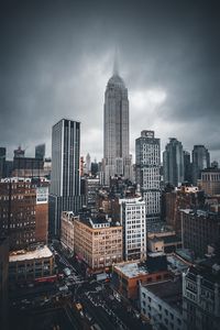 Skyscrapers in city against cloudy sky