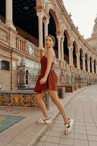 Side view of woman sitting on a building in seville. plaza de espana - spain square
