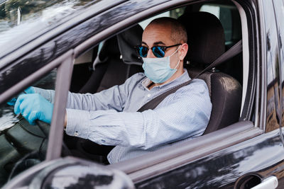 Man wearing mask while driving car