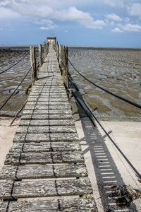 Wooden posts on beach against sky