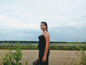 Woman standing on field against sky