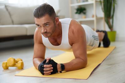 Side view of young woman exercising at gym