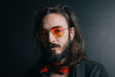 Close-up portrait of man sitting against wall at home