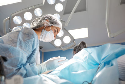 Midsection of woman wearing mask in bed