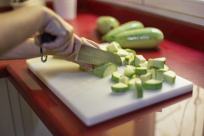 Midsection of person preparing food in kitchen at home