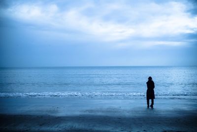 Full length of man standing on beach against sky