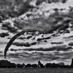 Low angle view of man paragliding against sky