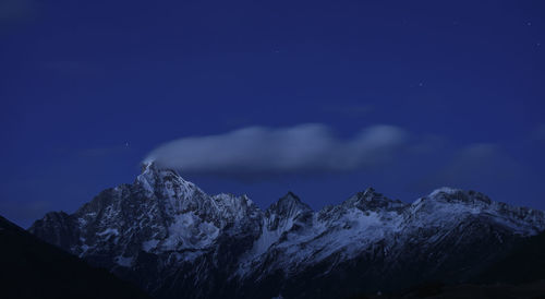 Scenic view of snowcapped mountains against sky at night