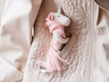 Cute fairy unicorn with pink mane. crocheted hand made toy in pocket of leather jacket. magic.