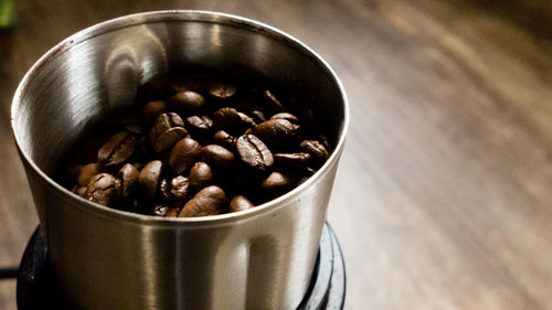 High angle view of roasted coffee beans in container on table