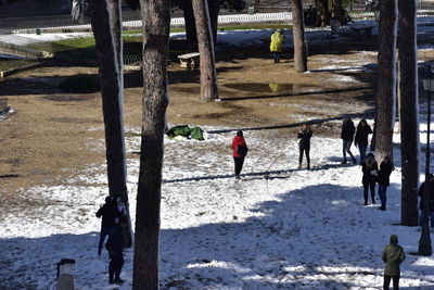 Rear view of people walking on snow covered land