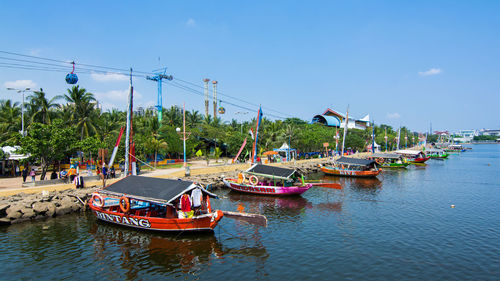 Boats moored in river against sky