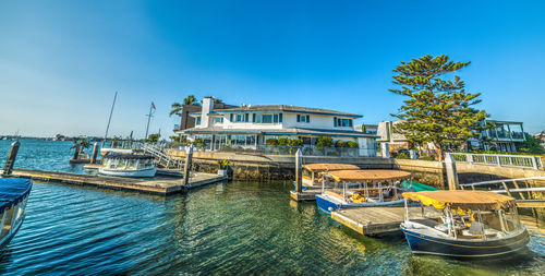 Sailboats moored in swimming pool against building