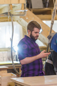 Man using smart phone in workshop