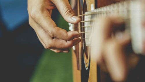 Midsection of man playing guitar