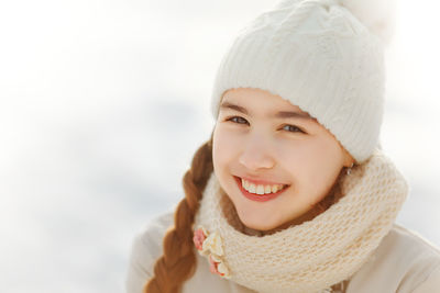 Portrait of smiling teenage girl standing outdoors during winter