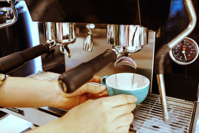 Midsection of woman holding coffee cup at cafe