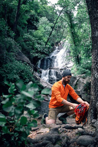 Man sitting on rock in forest