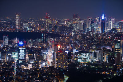 Illuminated cityscape against sky at night