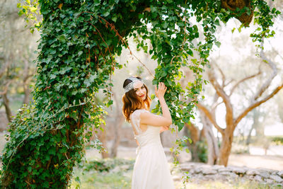 Woman standing by tree