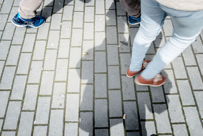 Low section of woman standing on footpath