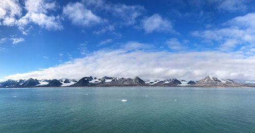 Scenic view of sea and mountains against blue sky