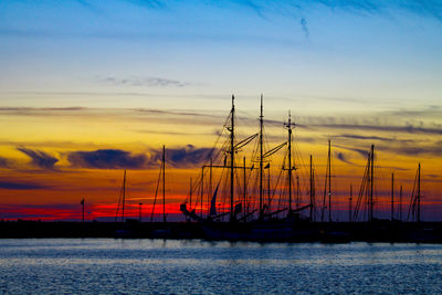 Silhouette sailboats on sea against sky during sunset