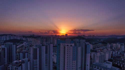 Aerial view of buildings against sky during sunset